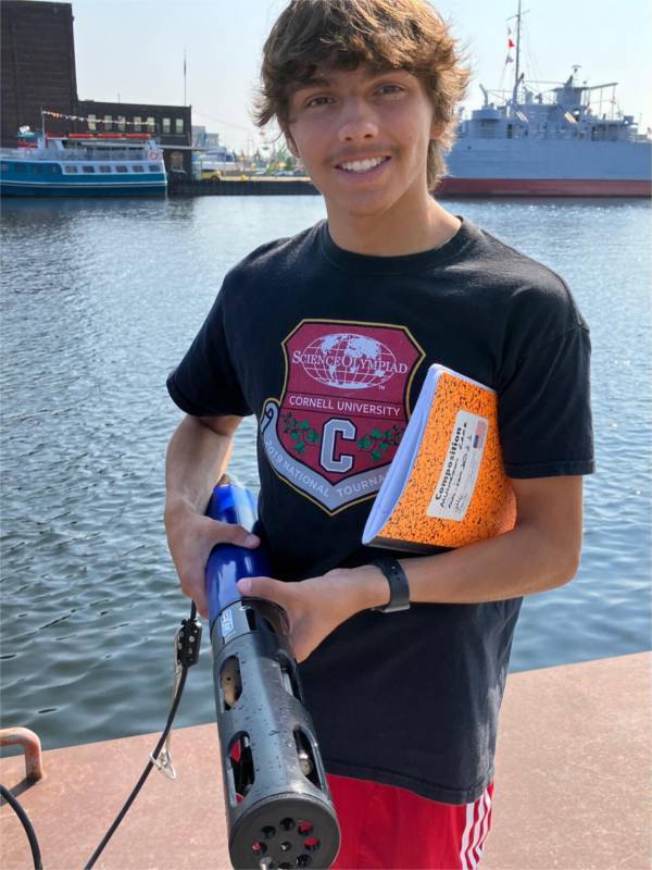 Conor Gabel holds a YSI next to Muskegon Lake